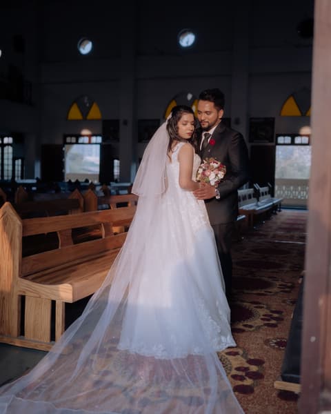Couple in the church aisle, her veil trailing