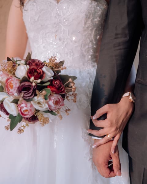 Bouquet beside the couple's joined hands