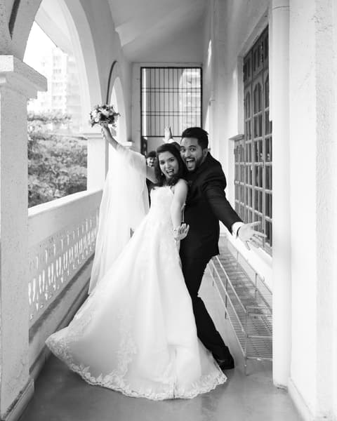 Couple laughing on a balcony, in black and white